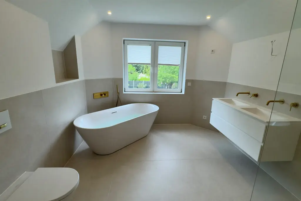 Fertige Badsanierung in Delmenhorst mit moderner Badewanne, Doppel-Waschbecken, Dusche und Toilette